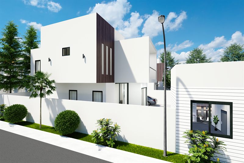 A house seen along its flank from the public road: a white rendered upper volume with a dark timber-clad bay slotted with vertical openings, a palm and clipped shrubs in the planted strip behind the boundary wall, a car in the forecourt, and the next house at the right.