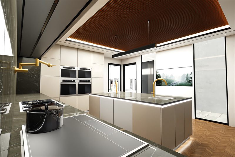 The kitchen from the hob end: the slatted timber ceiling running the length of the room, twin wall ovens set into a run of pale cabinetry, a brass pot-filler over the hob in the foreground, and the stone-topped island with a brass tap running out towards full-height glazing.