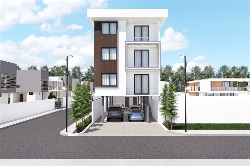 The block square on from the road: four storeys in white render with a timber-clad bay up the left of the front and stacked balconies at the centre, over an open ground floor where two cars are parked between the columns, with street lamps and boundary walls either side.